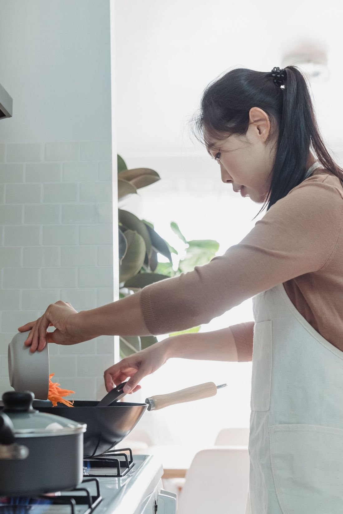 Seseorang memasak dalam wajan di dapur rumah